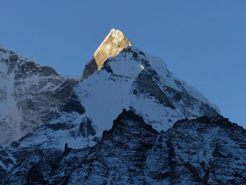 Scenic view of snowcapped mountains against clear blue sky