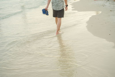 Low section of woman walking on beach