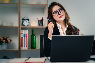 Young woman using smart phone on table