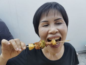 High angle view of woman eating from skewer