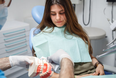 Portrait of female doctor examining patient at clinic