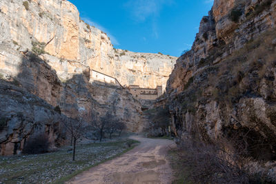 Road amidst rocky mountains against sky