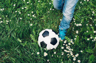 Low section of boy kicking soccer ball