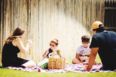 Family sitting on field at park