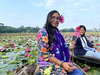 Women sitting on a boat in wetlands water.