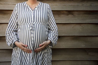 Midsection of woman standing on wood