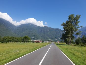 Road leading towards mountains against sky