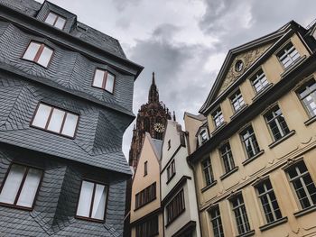 Low angle view of buildings against cloudy sky