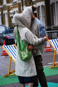 Rear view of man and woman on street in city