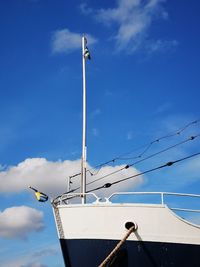 Low angle view of sailboat against blue sky