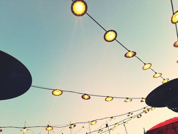 Low angle view of illuminated lanterns against clear sky