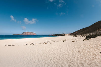 Scenic view of beach against blue sky