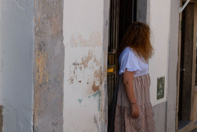 Rear view of woman standing against door