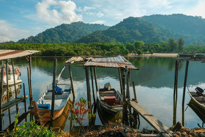 Boats moored in lake against sky