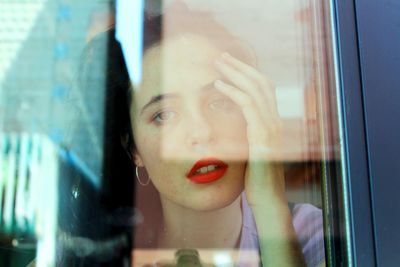 Portrait of woman looking through window