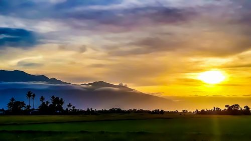 Scenic view of silhouette mountains against orange sky