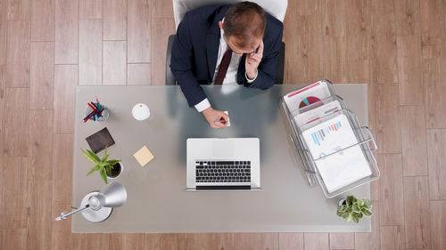 High angle view of man using laptop on table