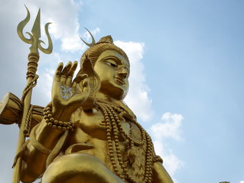 Low angle view of statue against temple against sky