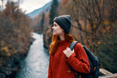 Woman looking away while standing on snow