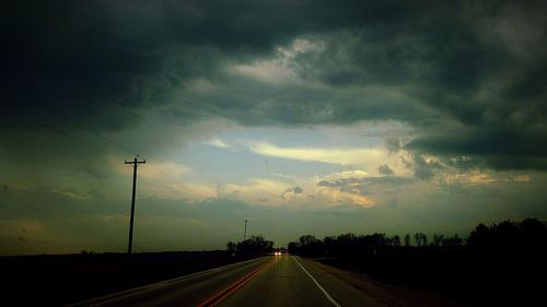 Silhouette of road against cloudy sky