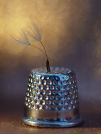 Close-up of wine in jar on table against wall