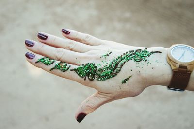 Cropped hand of woman with henna tattoo