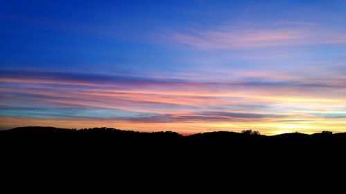 Scenic view of silhouette landscape against sky at sunset