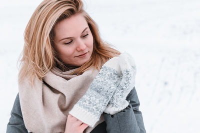 Portrait of young woman standing on snow