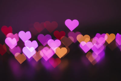 Defocused image of illuminated heart shape against black background