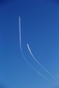 Low angle view of vapor trail against clear blue sky