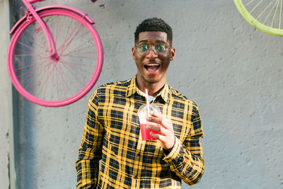 Portrait of young man standing against wall