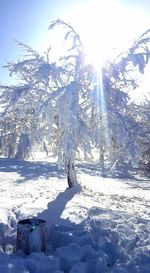 Scenic view of snow covered mountains against bright sun