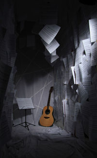 Guitar and sheet music in darkroom