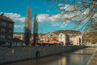 Bridge over river against buildings in city