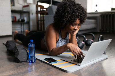 Positive african american athlete browsing laptop