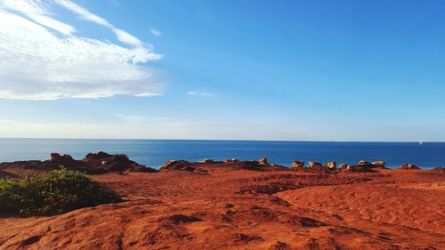 View of calm beach against blue sky