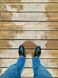 Low section of man standing on wood