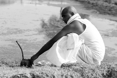 Side view of a woman sitting on field