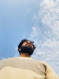 Rear view of man photographing against sky