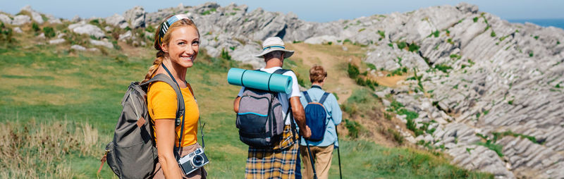 Happy young woman looking camera hiking with her grandparents