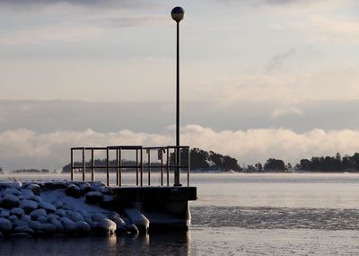 Boats in sea against cloudy sky