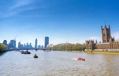 Boats in river with buildings in background