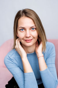 Portrait of young woman against white background