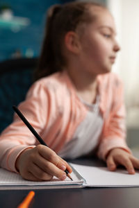 Midsection of woman reading book while sitting on table