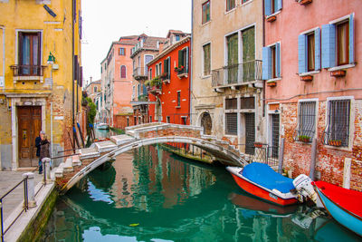A canal with boats, a bridge and reflections on water, venice, italy