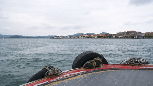 Boats moored at harbor against sky