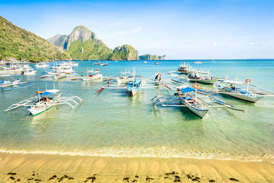 Boats moored in sea against sky