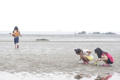 Friends playing on sand at beach