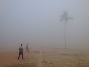 Rear view of man on beach against sky