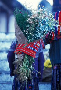 Rear view of woman carrying flowers